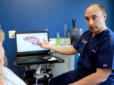 Doctor Goldberg showing a patient a laptop with digital impression of teeth