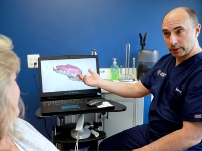Doctor Goldberg showing a patient a laptop screen with digital impression of teeth