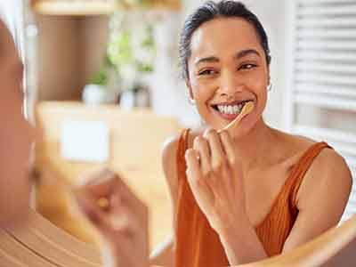 Woman smiling while brushing her teeth