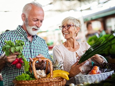 Senior couple purchasing vegetables at a farmer’s market