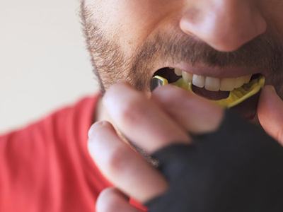 Close up of man inserting a mouthguard before playing sports