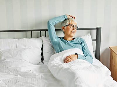 Senior woman relaxing in bed during recovery 