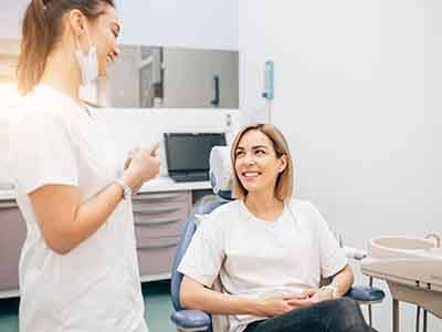 Dentist and patient smiling in exam room