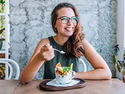 Smiling woman eating healthy breakfast