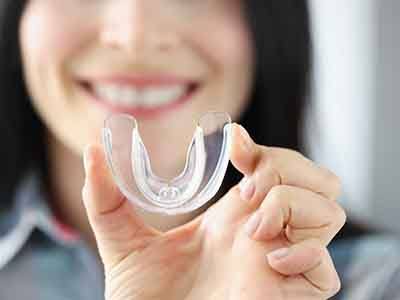 Woman holding clear mouthguard