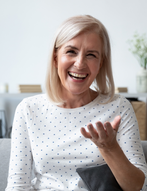 Senior woman laughing while sitting on couch